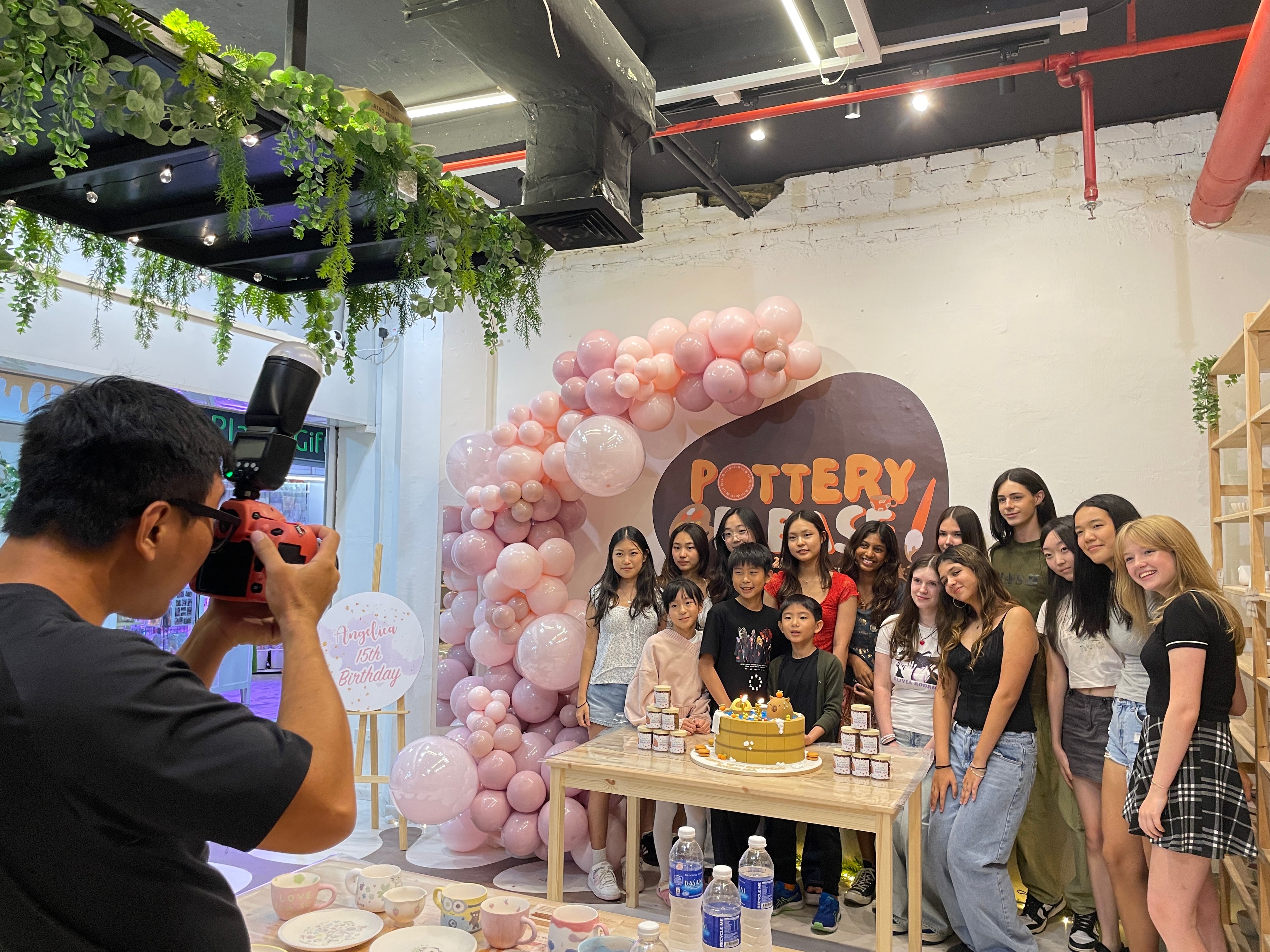 Happy guests celebrating a birthday with a pottery painting party at PotteryPlease in Singapore.