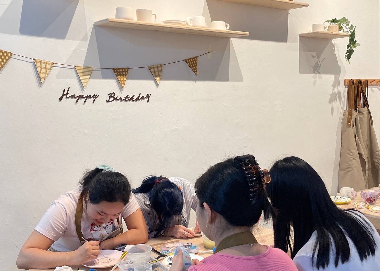 Friends celebrating a birthday with a pottery painting session at PotteryPlease studio in Singapore