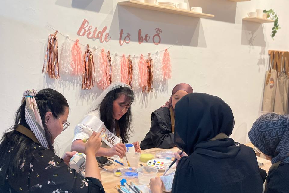 Bride-to-be and her friends enjoying a fun bachelorette pottery painting party at PotteryPlease in Singapore