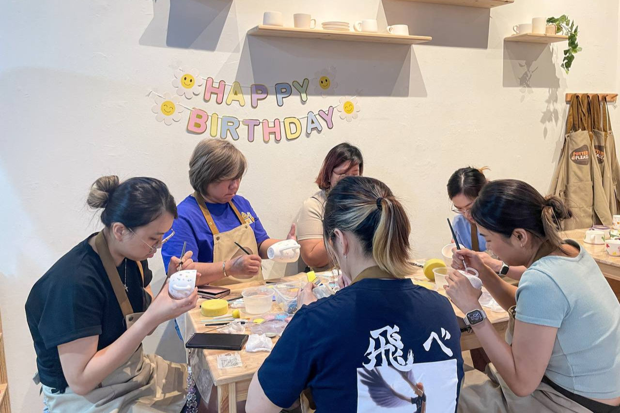 Happy friends and family celebrating birthday with pottery painting activity